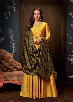 Celebrate This Festive Season Wearing This Designer Readymade Gown In Yellow Colored Top Paired With Black Colored Bottom. This Gown Is Silk Based Beautified With Pattern Over Yoke And Hand Work. Buy This Now.