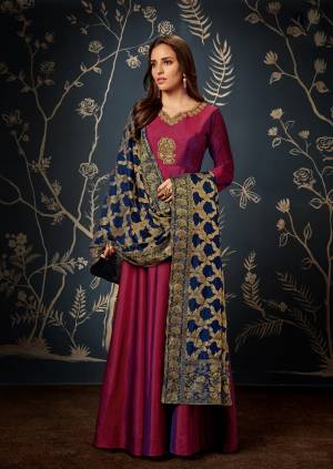 Add This Beautiful Designer Readymade Gown To Your Wardrobe In Magenta Pink Color Paired With Contrasting Navy Blue Colored Dupatta. This Readymade Gown Is Silk Based Beautified With Embroidery, and Weave Over The Dupatta.