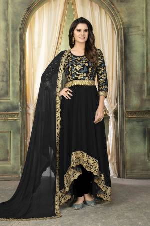 For A Bold And Beautiful Look, Grab This Bold Colored Designer Suit With High Low Pattern In Black Color Paired With Black Colored Bottom And Dupatta. Its Top And Dupatta Are Fabricated On Georgette Paired With Santoon Bottom. It Has Heavy Embroidered Yoke With Lace Borders. 