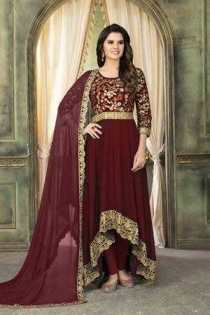 Here Is A Royal Color That One Can Wear, Grab This Designer Floor Length Suit In Maroon Color Paired With Maroon Colored Bottom And Dupatta. Its High Low Patterned Top Is Fabricated On Georgette Paired With Santoon Bottom And Georgette Dupatta. 