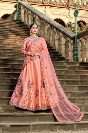 A Must Have Beautiful Shade In Ever Womens Wardrobe Is Here With This Heavy Designer Lehenga Choli In Peach Color Paired With Peach Colored Dupatta. Its Blouse And Lehenga Are Satin Based Paired With Net Fabricated Dupatta. All Its Fabric Ensures Comfort And A Pretty Look.