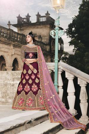 Look The Prettiest Of All Wearing This Heavy Designer Lehenga Choli In Wine Color Paired With Baby Pink Colored Dupatta. Its Blouse And Lehenga Are Silk Based Paired With Net Fabricated Dupatta. It Is Beautified With Heavy Embroidery Which Will Earn You Lots Of Compliments From Onlookers.