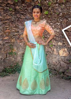 Give A Glam Look To Your Girl With This Designer Lehenga Choli In Peach Colored Blouse Paired With Pastel Green Lehenga And Light Green Colored Dupatta. Its Blouse And Lehenga Are Art Silk Based Paired With Net Fabricated Dupatta. Buy Now.