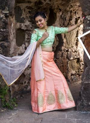 Give A Glam Look To Your Girl With This Designer Lehenga Choli In Pastel Green Colored Blouse Paired With Peach Lehenga And Light Peach Colored Dupatta. Its Blouse And Lehenga Are Art Silk Based Paired With Net Fabricated Dupatta. Buy Now.
