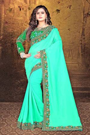 Grab This Beautiful And Attractive Looking Saree In Sea Green Color Paired With Contrasting Dark Green Colored Blouse. This Saree Is And Blouse Are Silk Based Beautified With Heavy Embroidery Over The Blouse and Saree Lace Border.