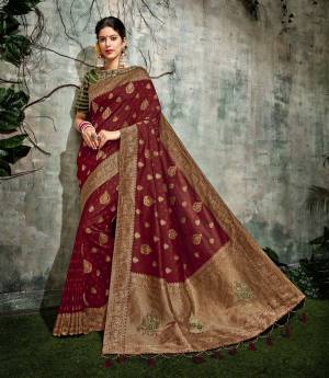 Be solely devoted to the traditions and heritage of India by draping this magnificent maroon silk saree with green blouse  and appear spectacular. 