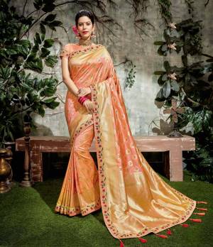Exude a sense of true beauty and flamboyance in this floral-motif weaved peach saree adorned with matching tassels /