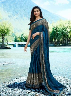 Add This Very Beautiful Saree In Blue Color Paired With Blue Colored Blouse. This Saree Is Fabricated On Georgette Paired With Art Silk Fabricated Blouse. It Is Beautified With Prints And Lace Border. 