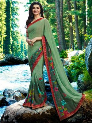 Celebrate This Festive Season Wearing This Designer Printed Saree In Light Green Color Paired With Contrasting Red Colored Blouse. This Saree Is Georgette Based Paired With Art Silk Fabricated Blouse. It Is Beautified With Floral Prints All Over The Saree. 