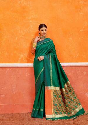 This Festive Season, Be The Most Gorgeous One Wearing This Lovely Silk Based Saree In Dark Green Color Paired With Contrasting Orange Colored Blouse. This Saree And Blouse Are Fabricated On Handloom Art Silk Beautified With Weave Over The Pallu. 