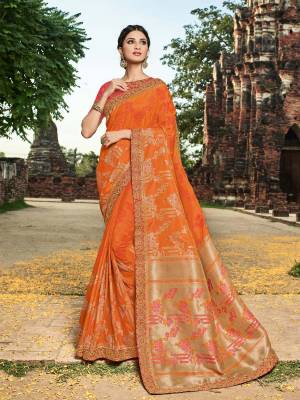 You Look elegant and stylish this festive season by draping this orange and gold color banarasi silk jacquard saree. Ideal for party, festive & social gatherings. this gorgeous saree featuring a beautiful mix of designs. Its attractive color and designer heavy embroidered design, zari resham work, banarasi silk sarees, beautiful floral design work over the attire & contrast hemline adds to the look. Comes along with a contrast unstitched blouse.