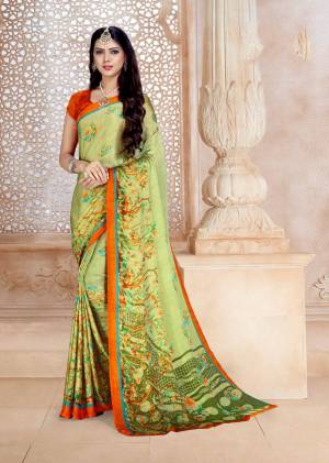 New Shade In Green Is Here With This Saree In Pear Green Color Paired With Contrasting Orange Colored Blouse. This Satin Georgette Based Saree Ensures Superb Comfort All Day Long. 