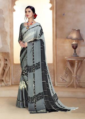 Flaunt your Rich And Elegant Taste Wearing This Saree In Grey Color Paired With Grey Colored Blouse. This Saree And Blouse Are Fabricated On Satin Georgette Beautified With Minimal Prints. 