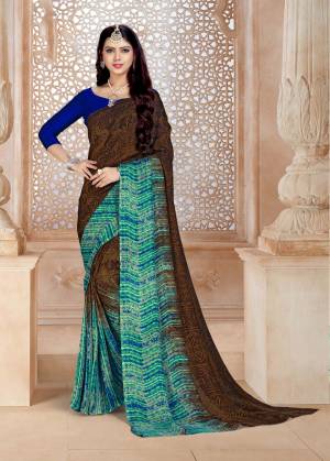 Unique Color And Patterned Saree Is Here In Brown And Blue Color Paired With Royal Blue Colored Blouse. This Saree And Blouse Are Satin Georgette Based Beautified With Prints All Over. 