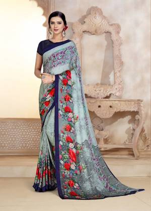 You Will Earn Lots Of Compliments Wearing This Pretty Shade In Light Grey Colored Saree Paired With Navy Blue Colored Blouse. This Saree And Blouse Are Fabricated On Satin Georgette Beautified With Prints. 