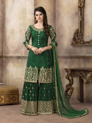 Celebrate This Festive Season with The Proper Festive Look, Wearing This Designer Sharara Suit In Dark Green Color Paired With Dark Green Colored Bottom And Dupatta. Its Top Is Silk Based Paired With Georgette Bottom And Net Dupatta. 