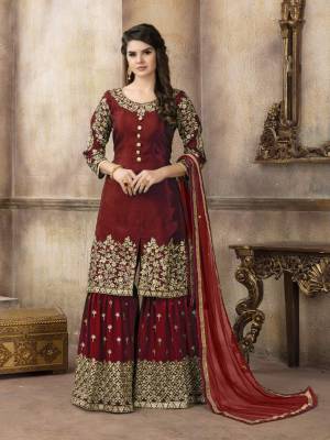 Adorn The Beautiful Royal Look Wearing This Designer Sharara Suit In Maroon Color. Its Top Is Silk Based Paired With Georgette Bottom And Net Dupatta. It Is Beautified With Jari Embroidery And Stone Work .