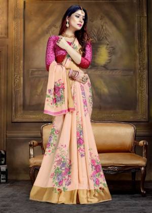 A Must Have Shade In Every Womens Wardrobe Is Here In Peach Color Paired With Contrasting Dark Pink Colored Blouse. This Pretty Saree Has Multi Colored Floral Prints Fabricated On Art Silk. 