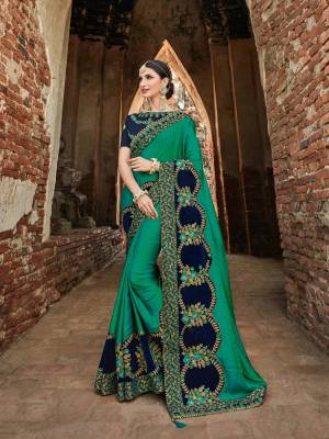 The fabulous pattern makes this Teal green color two tone silk saree. Ideal for party, festive & social gatherings. this gorgeous saree featuring a beautiful mix of designs. Its attractive color and designer heavy embroidered design, stone and zari design work, gotta design and heavy designer blouse, beautiful floral design all over in saree work over the attire & contrast hemline adds to the look. Comes along with a contrast unstitched blouse.