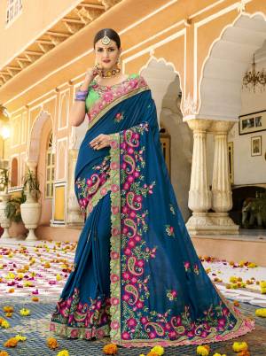 Grab This Beautiful Designer Saree For The Coming Festive And Wedding Season, This Attractive Blue Colored Saree Is Paired With Contrasting Green Colored Blouse. This Saree And Blouse Are Silk Based Beautified With Heavy Embroidery Work Giving It A More Attractive Look .