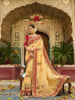 Celebrate This Festive Season Wearing This Lovely Designer Saree In Light Yellow Color Paired With Contrasting Red Colored Blouse. This Saree And Blouse Are Fabricated On Silk Beautified With Heavy Jari And Thread Work .