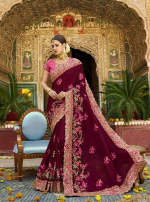 For A Royal Look, Grab This Heavy Designer Saree In Maroon Color Paired With Contrasting Pink Colored Blouse. This Saree And Blouse Are Silk based Beautified With Jari And Thread Work .