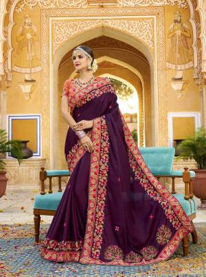 Bright And Visually Appeaking Color Is Here With This Designer Heavy Saree In Wine Color Paired With Contrasting Orange Colored Blouse. This Saree And Blouse Are Silk Based Beautified With Heavy Embroidery. 