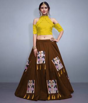 Here Is A Lovely Patterned Designer Lehenga Choli For Festive, Marriage Or Any Occasion Wear. Its Blouse Is In Yellow Color Paired With Contrasting Brown Lehenga. Its Blouse IS Fabricated On Nylon Silk Paired With Art Silk Lehenga. It IS Beautified with Patch Work And Tassels. 