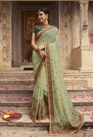 This Season Is About  Subtle Shades And Pastel Play, So Grab This Designer Saree In Pastel Green Color Paired With Pine Green Colored Blouse. This Saree Is Fabricated On Orgenza Paired With Art Silk Fabricated Blouse. It Is Beautified With Heavy Embroidery All Over.