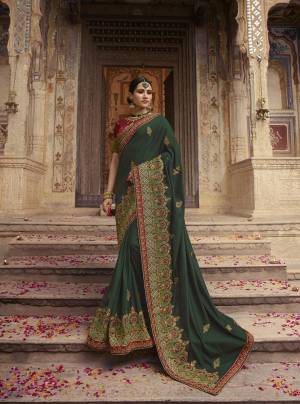 For A Rich Look, Grab This Designer Heavy Saree In Dark Green Color Paired With Contrasting Maroon Colored Blouse. This Saree And Blouse are Silk Beautified With Heavy Embroidery All Over. 