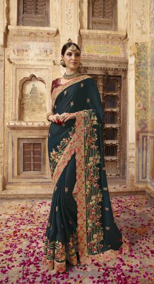 New Shade Is Here To Add Into Your Wardrobe With This Designer Saree In Prussian Blue Color Paired With Contrasting Maroon Colored Blouse. Its Rich And color And Heavy Embroidery Will Earn You Lots Of Compliments From Onlookers. 