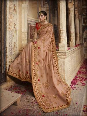 Flaunt Your Rich And Elegant Taste With Such Light Shades. This Lovely Light peach Colored Saree Is Paired With Contrasting Red Colored Blouse. This Saree And Blouse Are Silk Based Beautified With Heavy Embroidery All Over. 