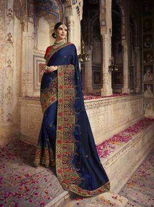 Enhance Your Personality Wearing This Designer Heavy Saree In Navy Blue Color Paired With Contrasting Red Colored Blouse. This Saree And Blouse Are Silk Based Beautified With Heavy Embroidery All Over. 
