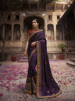 Catch All The Linelight Draping This Designer Saree In Dark Purple Color Paired With Contrasting Maroon Colored Blouse. This Saree And Blouse are Silk Based Beautified With Heavy Embroidery. 