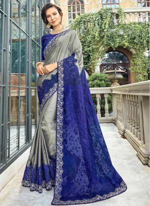 Here Is A Lovely Shade To Add Into Your Wardrobe With This Heavy Designer Saree In Grey And Blue Color Paired With Royal Blue Colored Blouse. This Saree And Blouse Are Silk Based Beautified With Heavy Embroidery Al Over. 