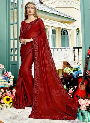 Adorn The Pretty Angelic Look Wearing This Heavy Designer Saree In Maroon Color Paired With Maroon Colored Blouse. This Saree Is Fabricated On Silk Chiffon Paired With Net And Art Silk Embroidered Blouse. 