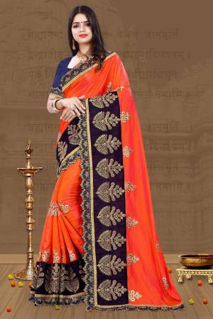 For A Proper Traditional Look, Grab This Designer Saree In Traditional Color Pallete With This Orange Colored Saree Paired With Contrasting Navy Blue Colored Blouse. This Saree And Blouse Are Art Silk Based Beautified With Embroidery All Over. 