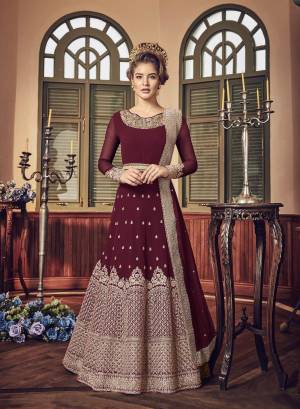 A Must Have Shade In Dark Is Here With This Heavy Designer Floor Length Suit In Maroon Color Paired With Maroon Colored Bottom And Dupatta. Its Long Heavy Top Is Georgette Based Paired With Santoon Bottom And Chiffon Dupatta. It Has Heavy Jari Embroidery Giving A Rich And Elegant Look To The Suit.