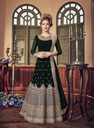 A Must Have Shade In Dark Is Here With This Heavy Designer Floor Length Suit In Dark Wine Green Paired With Dark Green Colored Bottom And Dupatta. Its Long Heavy Top Is Georgette Based Paired With Santoon Bottom And Chiffon Dupatta. It Has Heavy Jari Embroidery Giving A Rich And Elegant Look To The Suit.