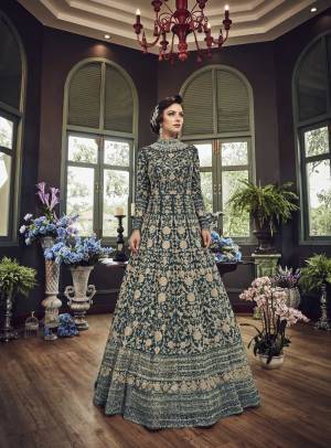 Add This Beautiful Heavy Designer Floor Length Suit In Teal Blue Color Paired With Teal Blue Colored Bottom And dupatta. Its Top And Dupatta Are Net Fabricated Paired With Art Silk Bottom. Also Its Top Is Beautified With Heavy Embroidery All Over.