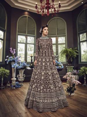 Add This Beautiful Heavy Designer Floor Length Suit In Dark Brown Color Paired With Dark Brown Colored Bottom And dupatta. Its Top And Dupatta Are Net Fabricated Paired With Art Silk Bottom. Also Its Top Is Beautified With Heavy Embroidery All Over.