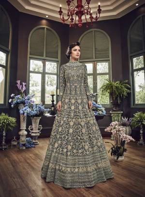Add This Beautiful Heavy Designer Floor Length Suit In Dark Grey Color Paired With Dark Grey Colored Bottom And dupatta. Its Top And Dupatta Are Net Fabricated Paired With Art Silk Bottom. Also Its Top Is Beautified With Heavy Embroidery All Over.