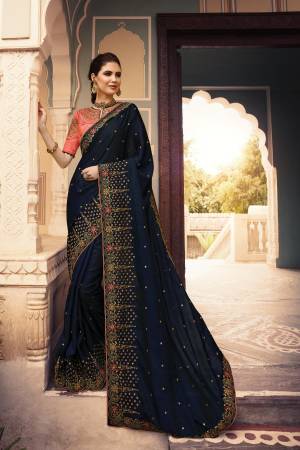 Catch All The Limelight Wearing This Designer Saree In Navy Blue Color Paired With Dark Peach Colored Blouse. This Saree Is Fabricated On Soft Silk Paired With Art Silk Fabricated Blouse. 