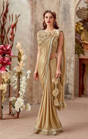 Ace up your style quotient in this subtle golden pre-pleated saree with an added quirk - the shoulder and short pallu flower. Add dainty