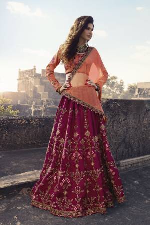 Add This Lovely Designer Lehenga Choli To Your Wardrobe With This Beautiful Color Pallete In Peach Colored Blouse And Dupatta Paired With Dark Pink Colored Lehenga. Its Blouse Is Fabricated On Art Silk Paired With Soft Silk Lehenga And Net Dupatta. 