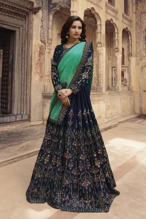 Enhance Your Personlity Wearing This Heavy Designer Lehenga Choli In Navy Blue Color Paired With Contrasting Sea Green Colored Dupatta. Its Blouse And Lehenga Are Fabricated On Velvet Paired With Net Dupatta. 