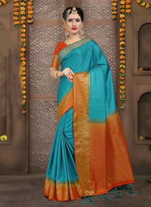 Here Is A Very Pretty Silk Based Saree In Turquoise Blue Color Paired With Contrasting Orange Colored Blouse. This Saree And Blouse Are Fabricated On Embossed Jacquard. Also It Is Light Weight And Durable. 