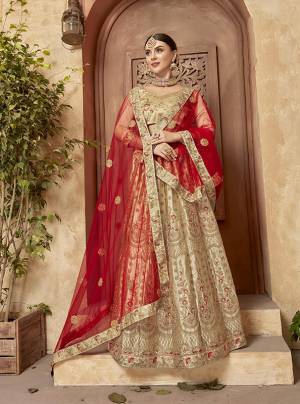 Here Is A Royal Designer Lehenga In Evergreen Combination In Beige Paired With Red Colored Dupatta. This Lehenga Choli IS Satin Silk Based Paired With Net Fabricated Dupatta. 