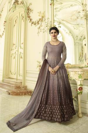 New Color Pallete Is Here With This Designer Floor Length Suit In Mauve And Brown Color Paired With Brown Colored Bottom And Mauve And Brown Shaded Dupatta. Its Top And Dupatta Are Fabricated On Net With Heavy Embroidery Over The Top. It Is Paired With Santoon Fabricated Bottom. Buy Now.