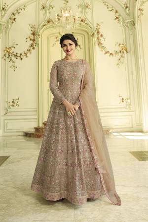 Here Is Lovely Shade With This Designer Floor Length Suit In Sand Grey Color Paired With Sand Grey Colored Bottom And Dupatta. Its Top And Dupatta Are Fabricated On Net Paired With Santoon Bottom. It Has Very Attractive Resham And Jari Embroidery With Stone Work. 